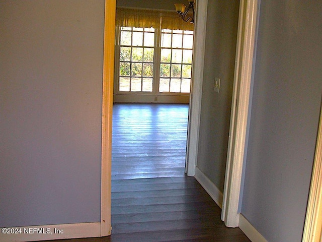 hall with dark hardwood / wood-style flooring and an inviting chandelier