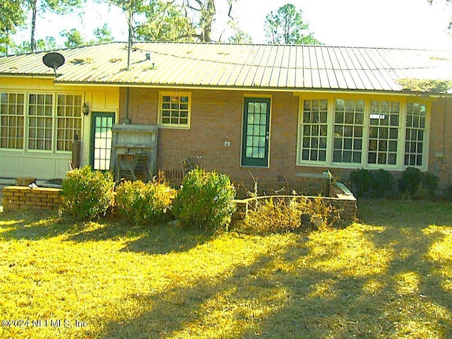 1113 Fieldcrest Rd, Jasper, FL 32052 - view of front of house with brick siding, a front yard, and a metal roof