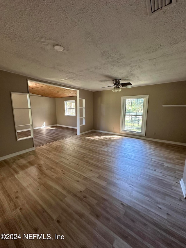 empty room with a textured ceiling, hardwood / wood-style flooring, and ceiling fan