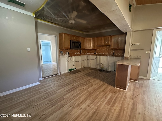 kitchen with backsplash, light hardwood / wood-style floors, and crown molding