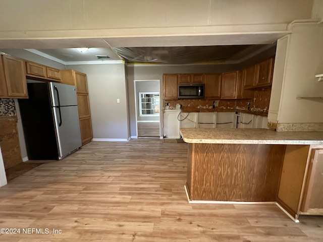 kitchen with kitchen peninsula, decorative backsplash, stainless steel appliances, and light hardwood / wood-style floors