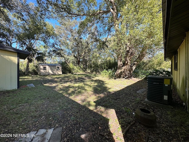 view of yard featuring a shed and central air condition unit