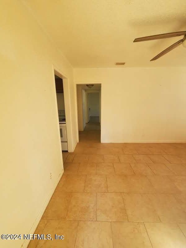 tiled empty room with ceiling fan