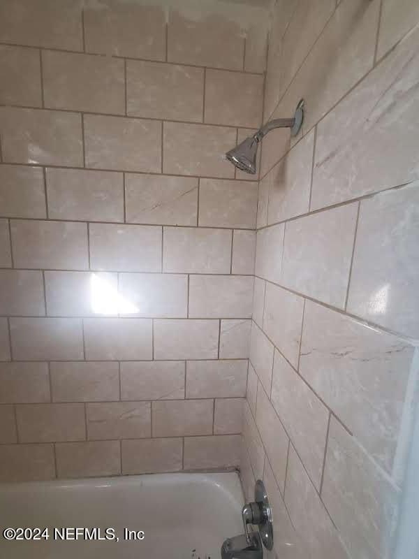 bathroom with tiled shower / bath combo