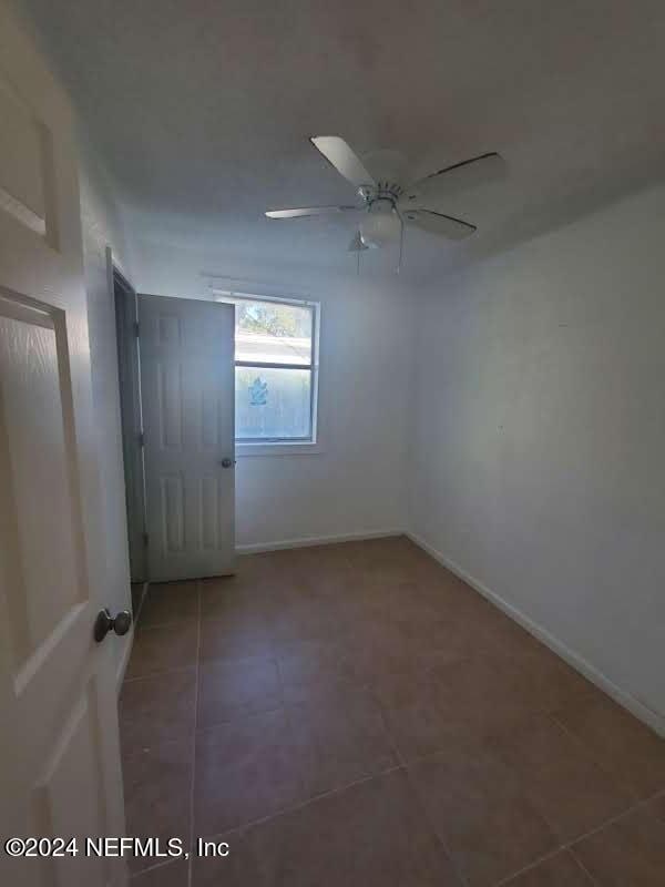 unfurnished room featuring tile patterned floors and ceiling fan