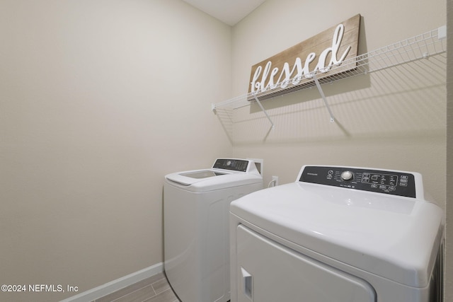 laundry room with washing machine and dryer and wood-type flooring