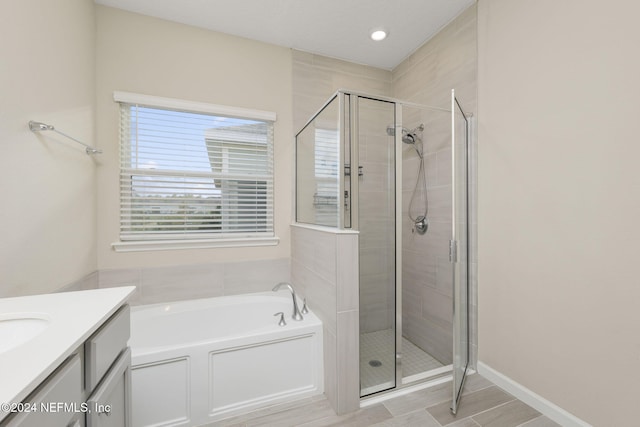 bathroom featuring vanity and shower with separate bathtub