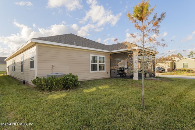 exterior space with cooling unit and a lawn