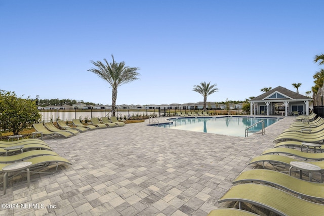 view of pool with an outbuilding and a patio