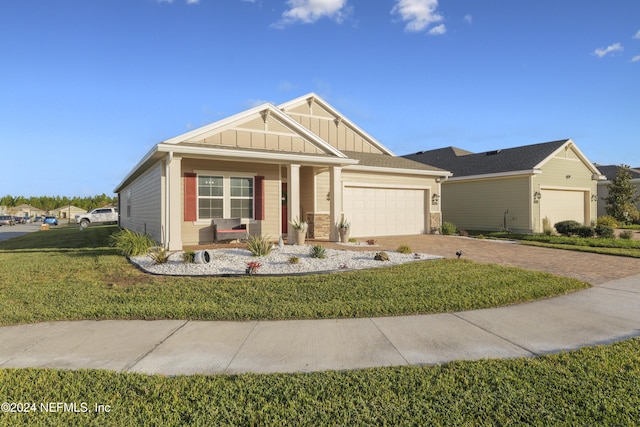 view of front of home featuring a front lawn, covered porch, and a garage