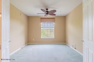 carpeted empty room featuring ceiling fan