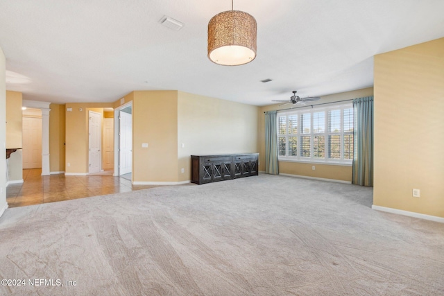 unfurnished living room featuring ceiling fan and light colored carpet