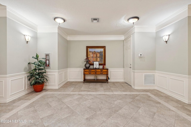 hallway with a textured ceiling and crown molding