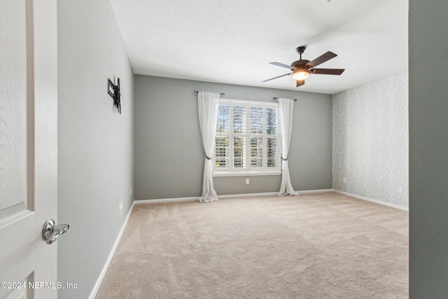 carpeted empty room with a textured ceiling and ceiling fan