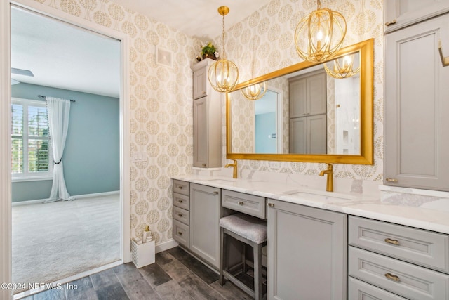 bathroom with hardwood / wood-style floors, vanity, and an inviting chandelier