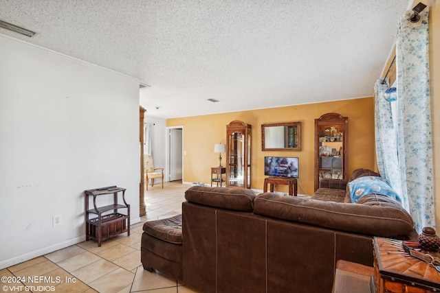 living room featuring light tile patterned flooring and a textured ceiling