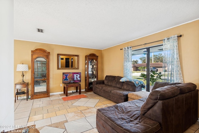 tiled living room featuring a textured ceiling