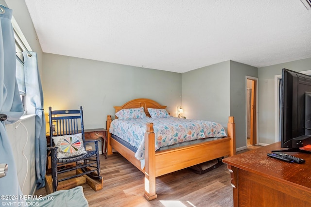 bedroom with hardwood / wood-style flooring and a textured ceiling