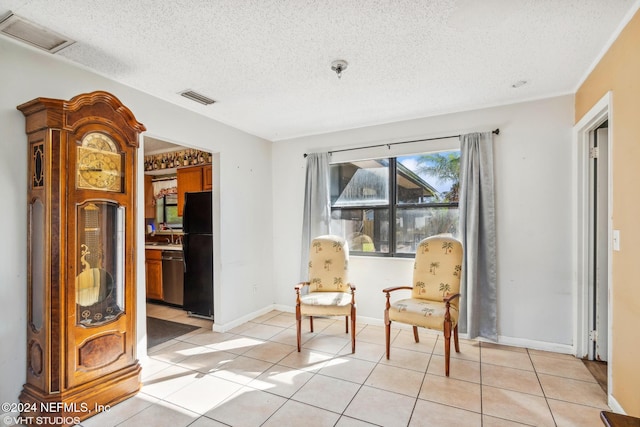 living area featuring light tile patterned flooring, sink, and a textured ceiling