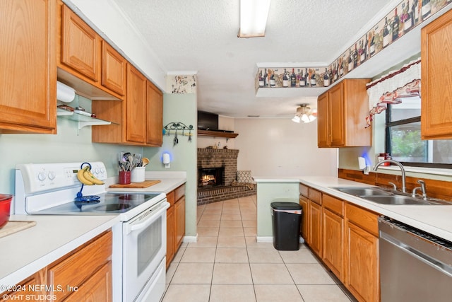 kitchen featuring dishwasher, sink, electric range, light tile patterned floors, and a textured ceiling