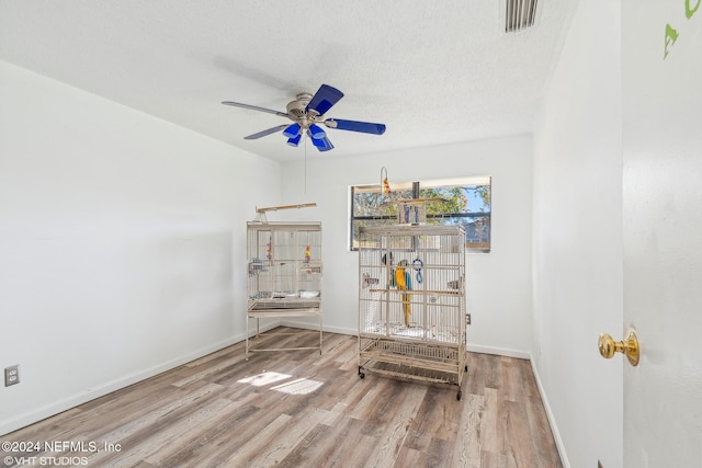 interior space featuring ceiling fan, wood-type flooring, and a textured ceiling