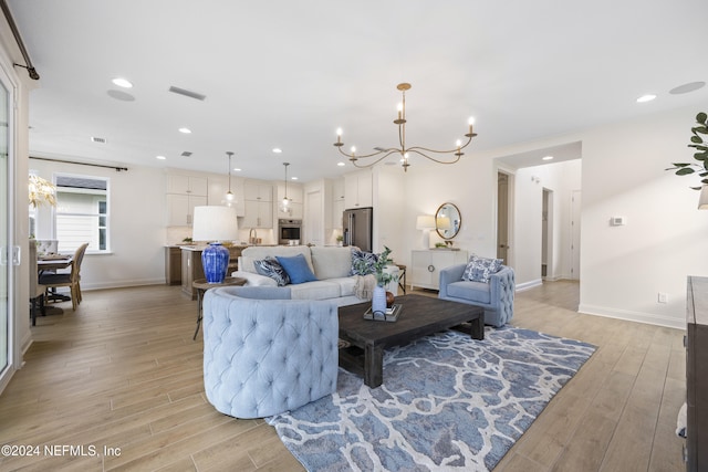 living room with light wood-type flooring and an inviting chandelier