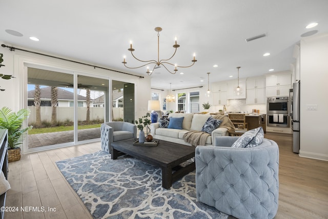 living room with light hardwood / wood-style flooring and a notable chandelier