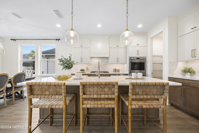 kitchen featuring white cabinets, appliances with stainless steel finishes, and a kitchen island with sink