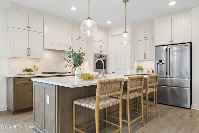 kitchen with white cabinets, an island with sink, and appliances with stainless steel finishes