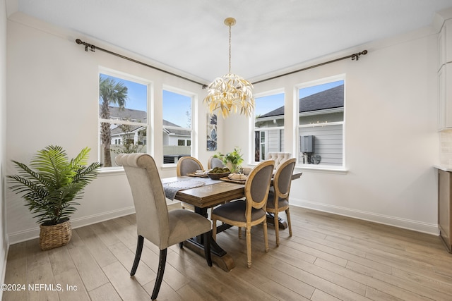 dining area with crown molding, a chandelier, and light wood-type flooring