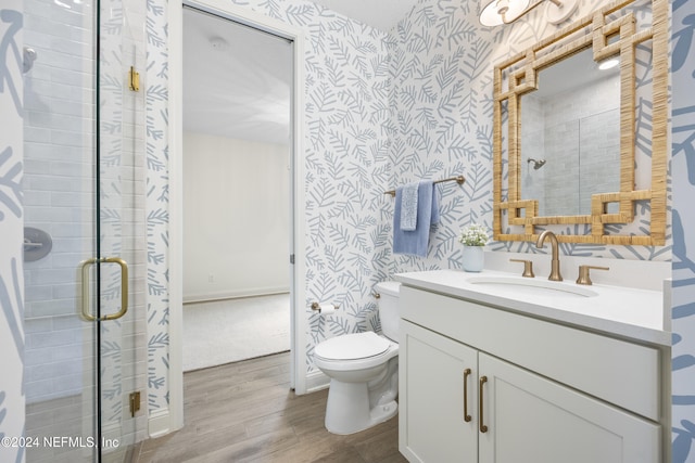 bathroom with vanity, wood-type flooring, a shower with shower door, and toilet