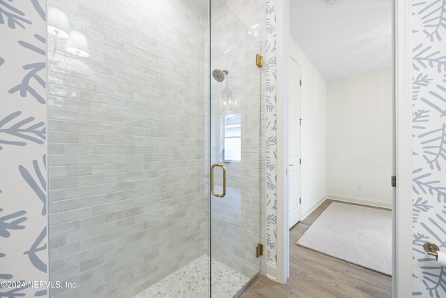 bathroom featuring hardwood / wood-style flooring and walk in shower