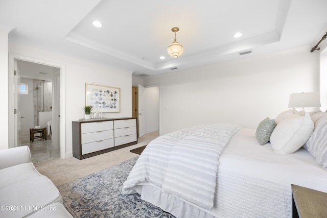 carpeted bedroom with a tray ceiling