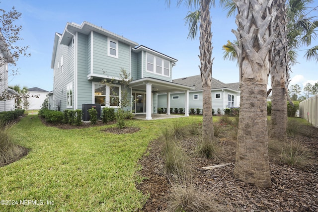 back of house with a lawn, central AC unit, and a patio area