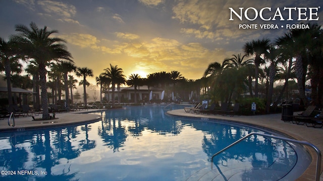 pool at dusk with a patio