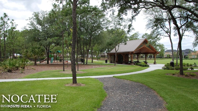 view of community with a gazebo, a playground, and a lawn