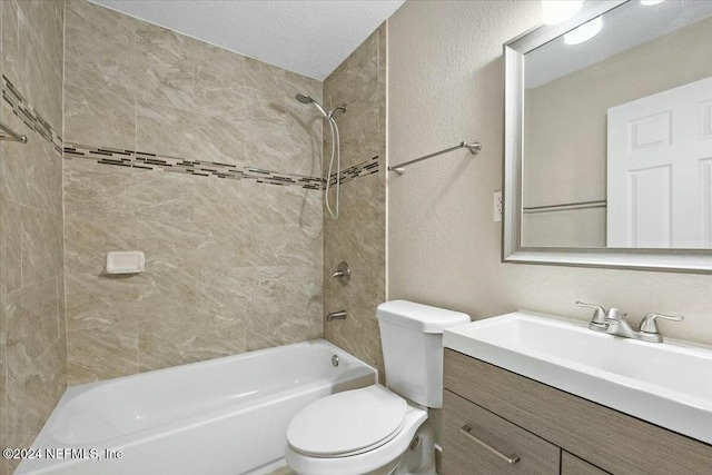 full bathroom featuring vanity, toilet, a textured ceiling, and tiled shower / bath