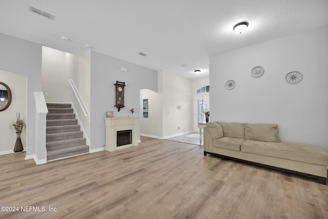 living room featuring a textured ceiling and light wood-type flooring