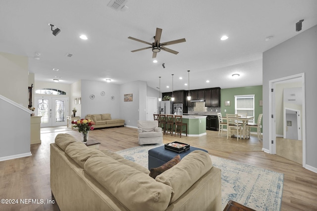 living room with ceiling fan, light wood-type flooring, and french doors