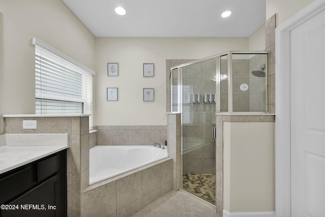 bathroom with tile patterned flooring, vanity, and shower with separate bathtub