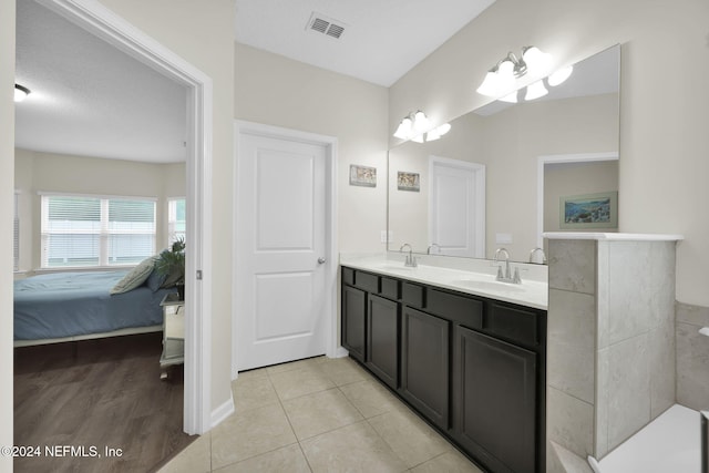 bathroom with tile patterned floors, vanity, and a textured ceiling