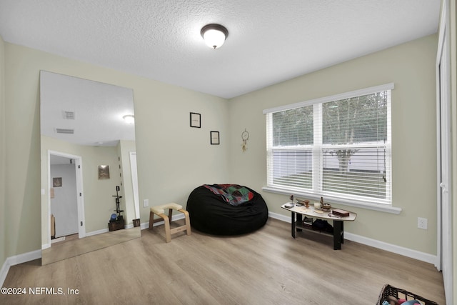 sitting room featuring a textured ceiling and light wood-type flooring