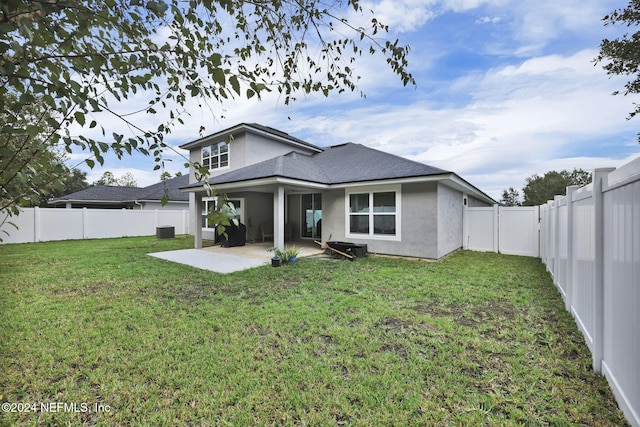 rear view of property with a patio area and a yard