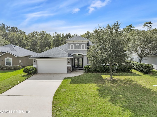 view of front of property featuring a garage, a front yard, and french doors