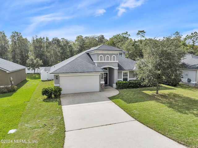 view of front of property with a front yard and a garage