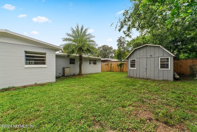 view of yard featuring a storage shed and central AC