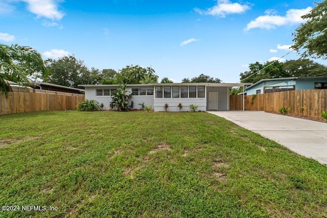 ranch-style home featuring a front lawn and a carport