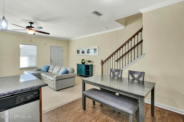 dining room with ceiling fan, ornamental molding, a textured ceiling, and hardwood / wood-style flooring