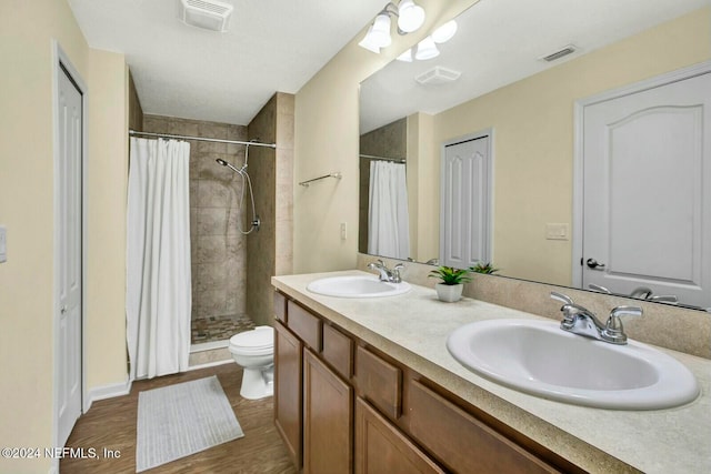 bathroom featuring a shower with shower curtain, vanity, hardwood / wood-style flooring, and toilet