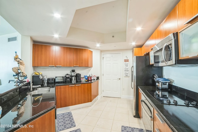 231 Riverside Dr Unit 1203-1, Daytona Beach, FL 32117 - kitchen featuring brown cabinets, a tray ceiling, wall oven, black electric stovetop, and light tile patterned floors